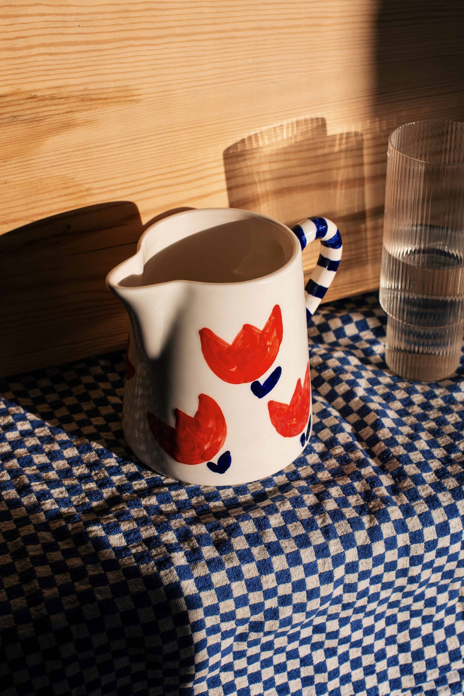 Pitcher with red tulips and stripes