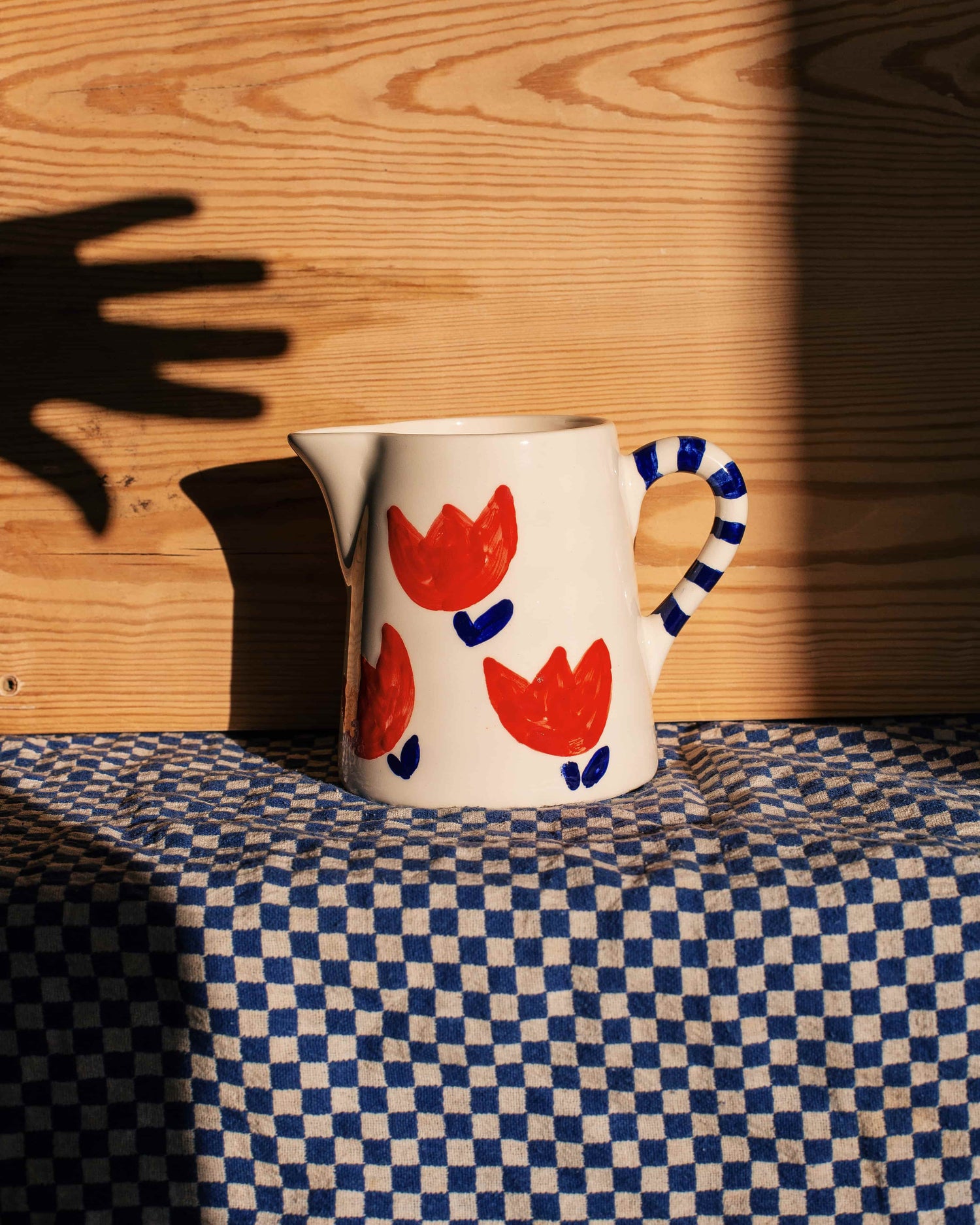 Pitcher with red tulips and stripes